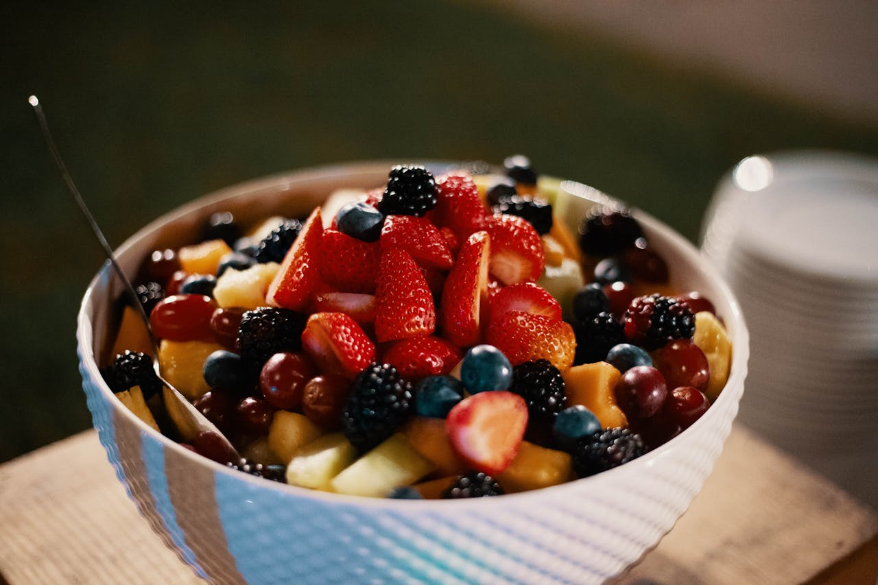 A colorful and fresh mixed fruit bowl featuring strawberries, blackberries, and grapes, perfect for a healthy breakfast or snack.